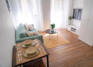sala de estar con sofá y mesa en Le Petit Martial - coeur de ville,refait à neuf,tout équipé, parking, en Châteauroux