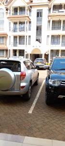 a group of cars parked in front of a building at Studio Apartment in Nairobi in Nairobi