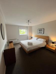 a bedroom with a large bed and a window at Century Wharf Apartments by Urban Space in Cardiff
