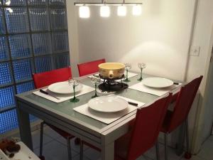 a dining room table with red chairs and agorithmic table at Apartment Neuschwändi 66 by Interhome in Engelberg