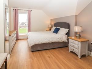 a bedroom with a large bed and a window at 20 Lighthouse Village in Fenit