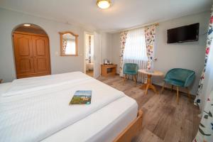 ein Hotelzimmer mit einem Bett und einem TV in der Unterkunft Landgasthof Hanselewirt in Schwangau