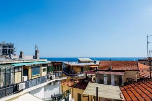 Blick auf die Dächer von Gebäuden und das Meer in der Unterkunft Sanremo Amazing Apartment with Private Parking in Sanremo