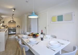 comedor con mesa blanca y sillas en Camomile Cottage, en Friston