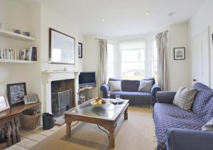 a living room with blue furniture and a fireplace at Caithness House in Southwold