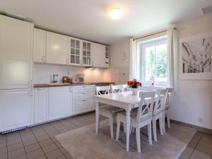 kuchnia z białymi szafkami oraz białym stołem i krzesłami w obiekcie Holiday Home Holiday Hill 42 by Interhome w mieście Lauterwasser