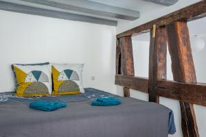 ein Schlafzimmer mit einem Holzbett mit blauen Handtüchern darauf in der Unterkunft Le Pied à Terre - Wifi - Golden Tree in Marmoutier