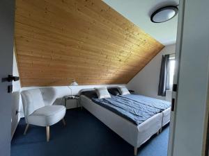 - une chambre avec un grand lit et une chaise dans l'établissement Holiday Home Holiday Hill 59 by Interhome, à Lauterwasser