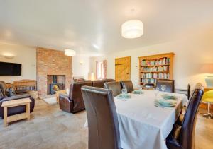 a dining room with a table and a fireplace at Canola Lodge in Darsham