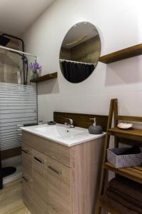 ein Bad mit einem Waschbecken und einem Wandspiegel in der Unterkunft Amadeu 1, Calella in Calella