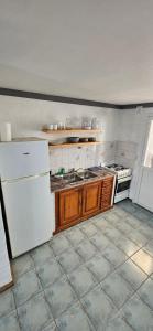 a kitchen with a white refrigerator and a stove at Duplex de Playa in Playa Unión