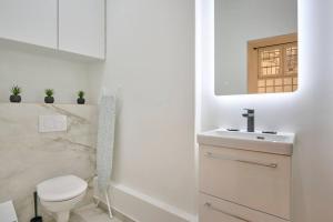 biała łazienka z toaletą i umywalką w obiekcie Marais - Modern apartment w Paryżu