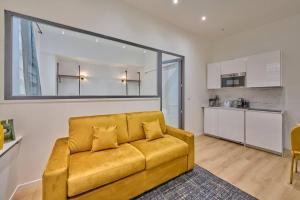salon z żółtą kanapą i kuchnią w obiekcie Marais - Modern apartment w Paryżu