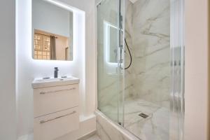 łazienka z prysznicem, umywalką i lustrem w obiekcie Marais - Modern apartment w Paryżu