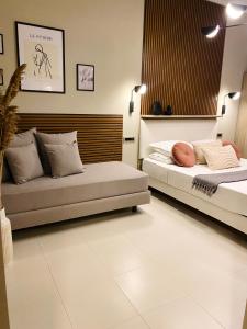 sypialnia z 2 łóżkami i kanapą w obiekcie Leonidas House w mieście Parga