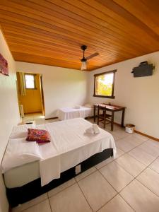 a large room with a bed and a table at Topo do Cipó Ecopousada Vegana in Serra do Cipo