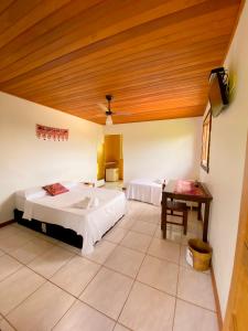 a bedroom with two beds and a wooden ceiling at Topo do Cipó Ecopousada Vegana in Serra do Cipo