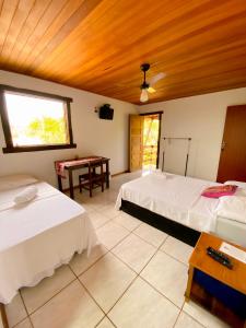 Un dormitorio con 2 camas y una mesa con una mesa. en Topo do Cipó Ecopousada Vegana, en Serra do Cipo