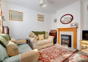 a living room with a couch and a fireplace at Clyde Cottage in Saxmundham