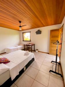 a bedroom with two beds and a wooden ceiling at Topo do Cipó Ecopousada Vegana in Serra do Cipo