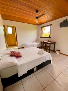 1 dormitorio con 2 camas y mesa. en Topo do Cipó Ecopousada Vegana, en Serra do Cipo