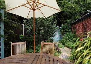 an umbrella sitting on top of a wooden table at Clyde Cottage in Saxmundham