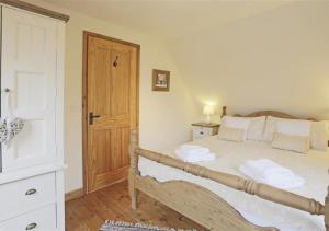 a bedroom with a bed and a wooden door at Cedar in Lowestoft
