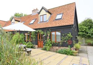 a house with an umbrella and a patio at Cedar in Lowestoft