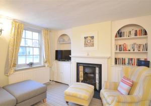 a living room with a couch and a fireplace at Christmas Cottage in Southwold