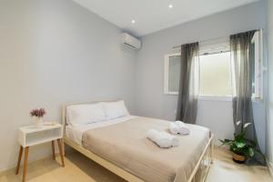 1 dormitorio con 1 cama con toallas en R&C Corfiot house, en Achílleion