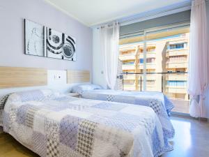 a bedroom with two beds and a large window at Apartment Vila de Oropesa X by Interhome in Oropesa del Mar