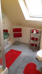 a attic room with red rugs and a toilet at Auf dem alten Deich in Sande