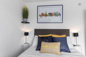 a bedroom with a white bed with blue and yellow pillows at Exeter City Centre Apartments Ashton Apartment in Exeter