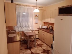 a small kitchen with a table and a refrigerator at Noclegi Murzynowskiego in Olsztyn