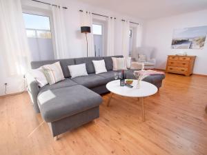 a living room with a couch and a table at Holiday Home Kiek in by Interhome in Norden