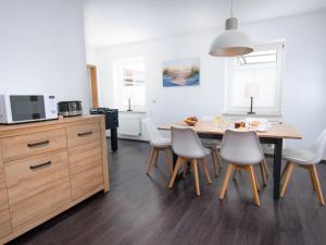 a kitchen and dining room with a table and chairs at Holiday Home Kiek in by Interhome in Norden