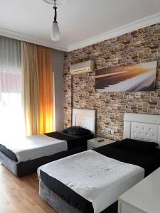 a bedroom with two beds and a brick wall at Melody City Otel in Alanya