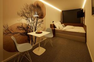 um quarto com uma cama, uma mesa e cadeiras em TIN INN l Erkelenz einfach gut - Das Hotel aus hochwertig ausgebauten Überseecontainern em Erkelenz