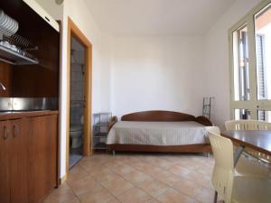 een slaapkamer met een bed en een tafel en een keuken bij Apartment L'Ancora-2 by Interhome in Porto Empedocle
