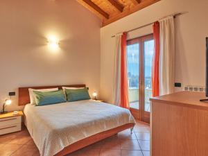a bedroom with a bed and a large window at Holiday Home Aaron by Interhome in Tremosine Sul Garda