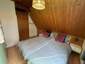 a bedroom with a large bed with a wooden ceiling at Chalet Waldrauschen by Interhome in Bad Arolsen