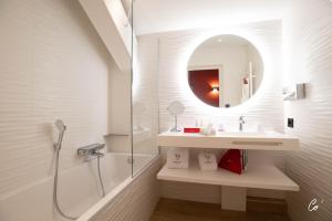 a bathroom with a shower and a sink and a mirror at Georges Blanc Parc & Spa - Relais & Chateaux in Vonnas
