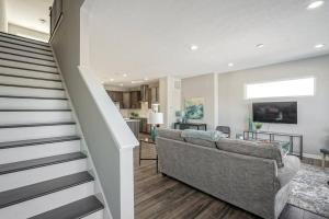a living room with a couch and a staircase at Luxury Blue Home minutes from everything Indy in Indianapolis