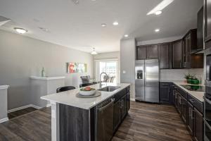 a large kitchen with a sink and a refrigerator at Luxury Blue Home minutes from everything Indy in Indianapolis