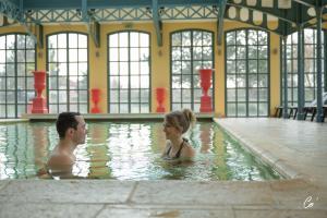 a man and a woman in a swimming pool at Georges Blanc Parc & Spa - Relais & Chateaux in Vonnas +102 photos
