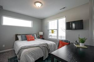 a bedroom with a bed and a table and a window at Luxury Blue Home minutes from everything Indy in Indianapolis