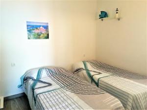 duas camas num quarto com uma fotografia na parede em GLOBAL-IMMO 5053 CASA BRAMER 28 em Roses