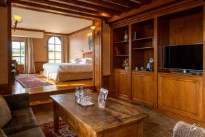 ein Wohnzimmer mit einem Bett und einem Couchtisch in der Unterkunft Georges Blanc Parc & Spa in Vonnas