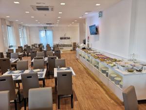 restauracja ze stołami i krzesłami oraz bufetem w obiekcie Hb Hotels Orchidea Blu w Rimini
