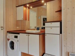 eine Küche mit einer Waschmaschine und einem Waschbecken in der Unterkunft Holiday Home Paulette - 450m from the sea in NW Jutland by Interhome in Løkken